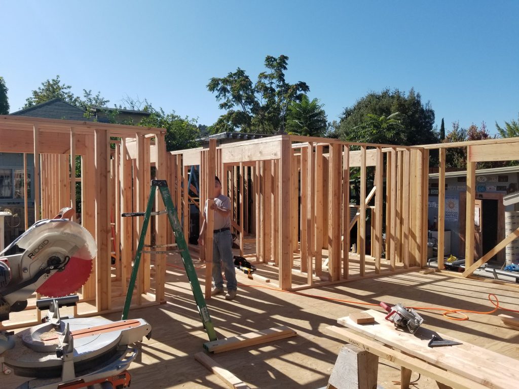 Construction crew framing new wooden walls during a home addition project.